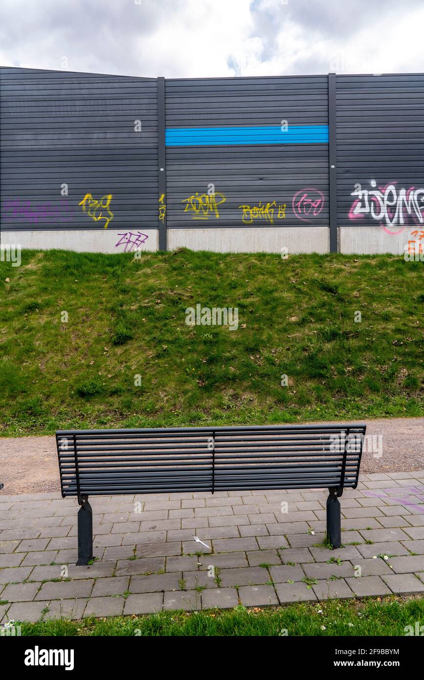 Green space, in Duisburg-Beck, park bench with view of the noise barrier of the motorway A42, Emscherschnellweg, NRW, Germany Stock Photo