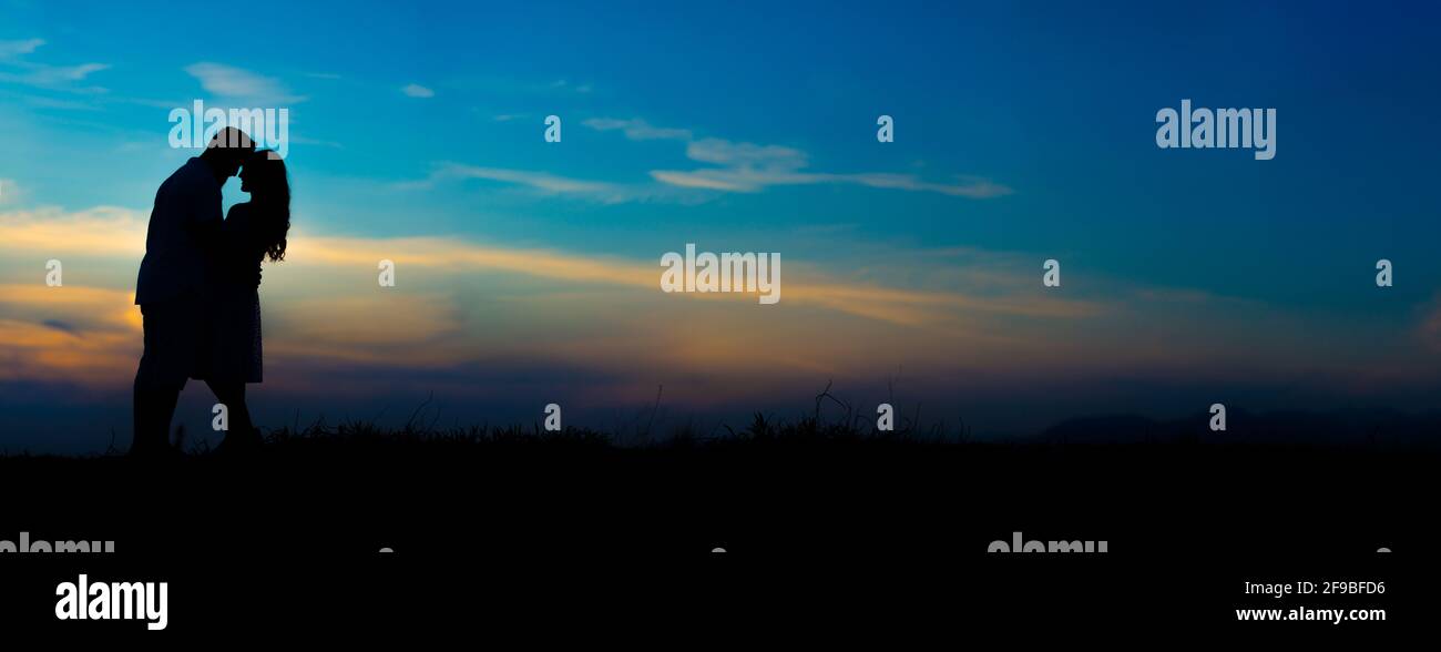 Silhouette of a couple kissing on a beautiful sunset sky background ...