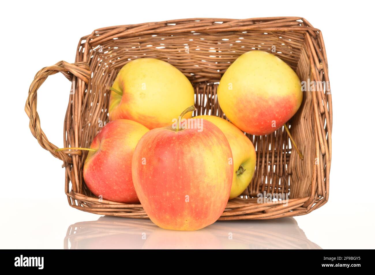 Two ripe organic, juicy, aromatic apples in a wicker basket of vines, close-up. Stock Photo
