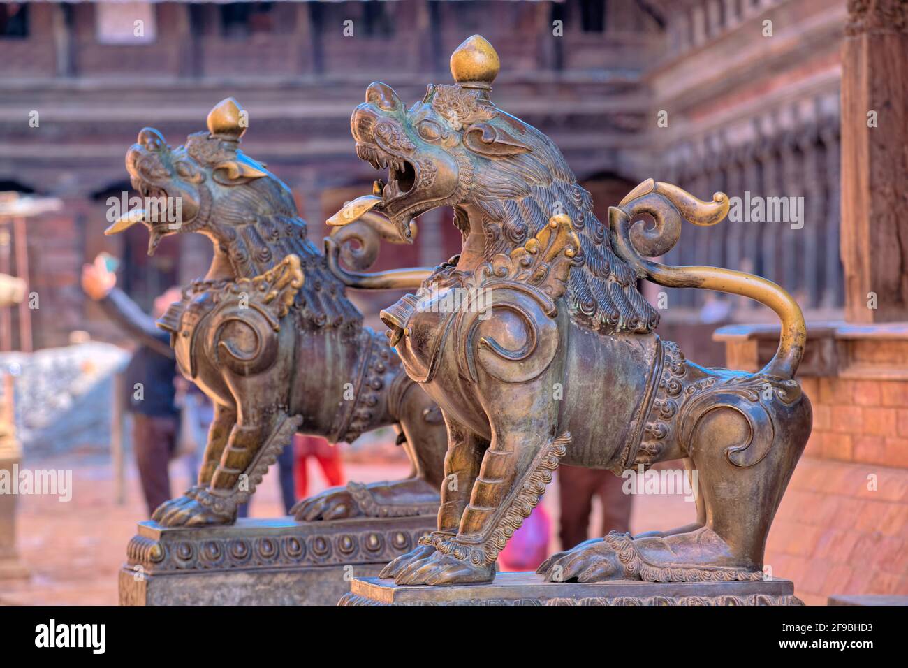 Most temples in Bhaktapur have stone guardians or some kind at their entrance way. Stone lions are the most common form of guardian, but these two are Stock Photo