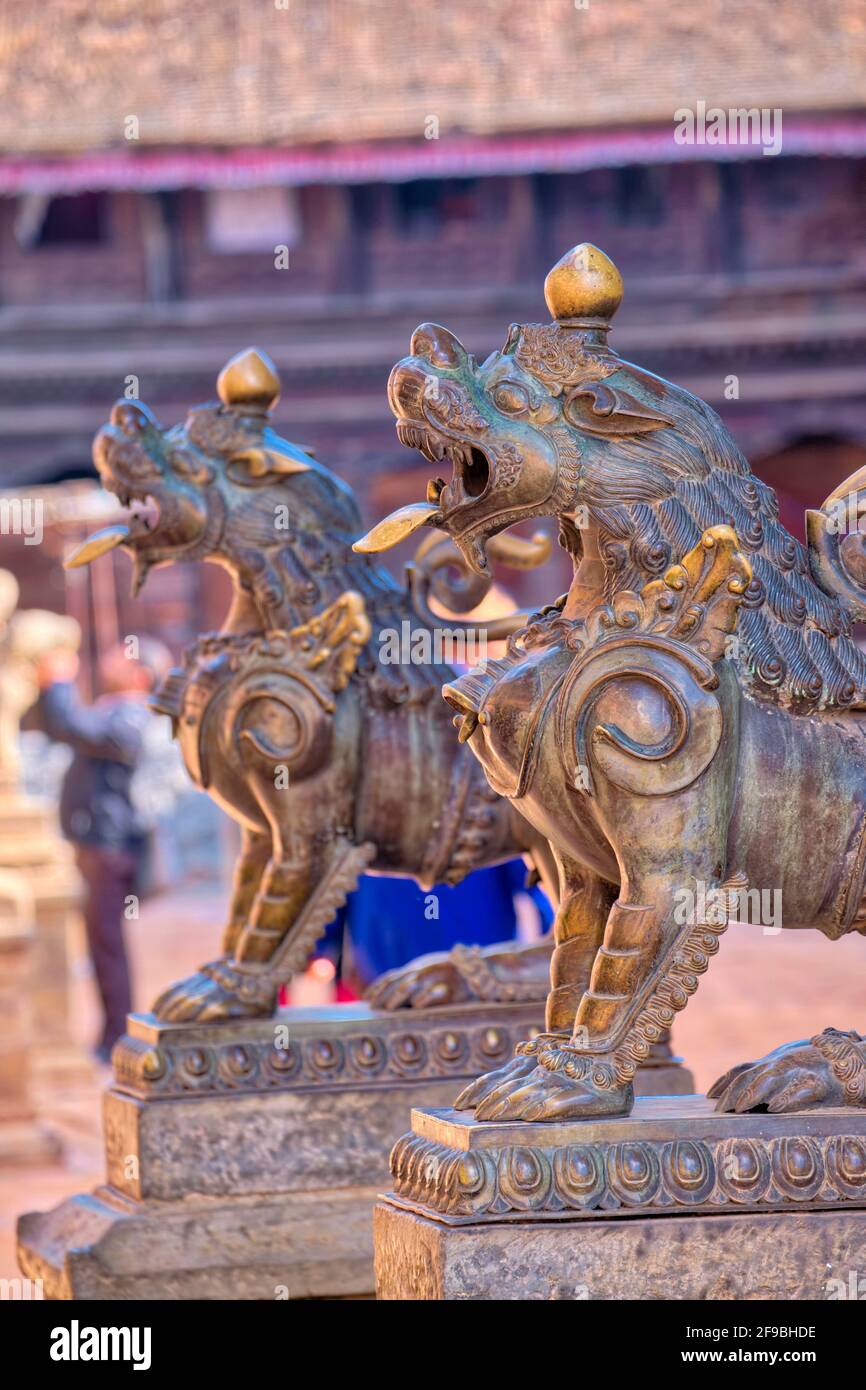 Most temples in Bhaktapur have stone guardians or some kind at their entrance way. Stone lions are the most common form of guardian, but these two are Stock Photo