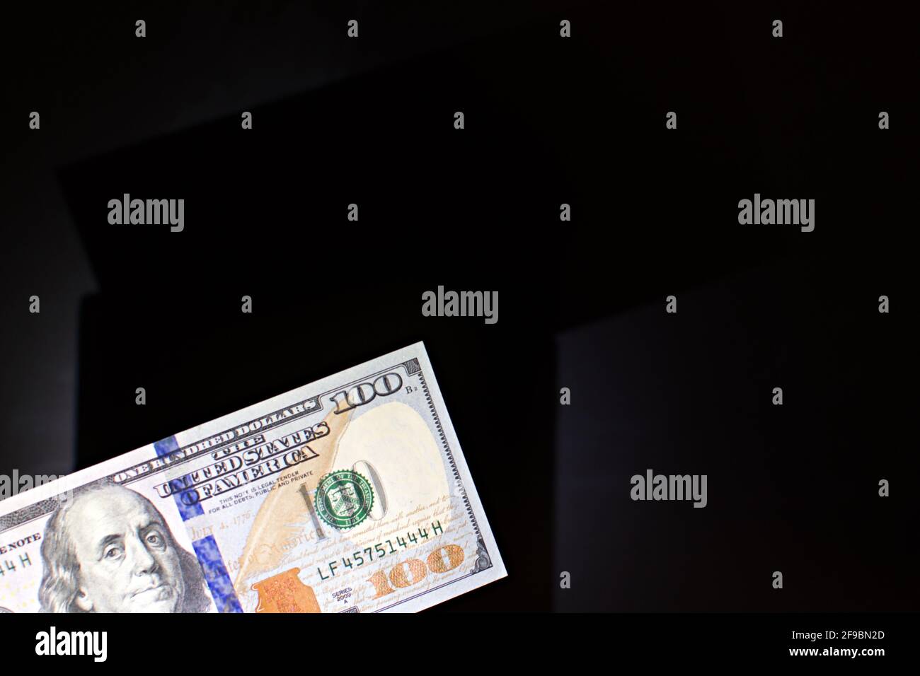 100 US dollars banknote on blurred black background with shadow Stock Photo