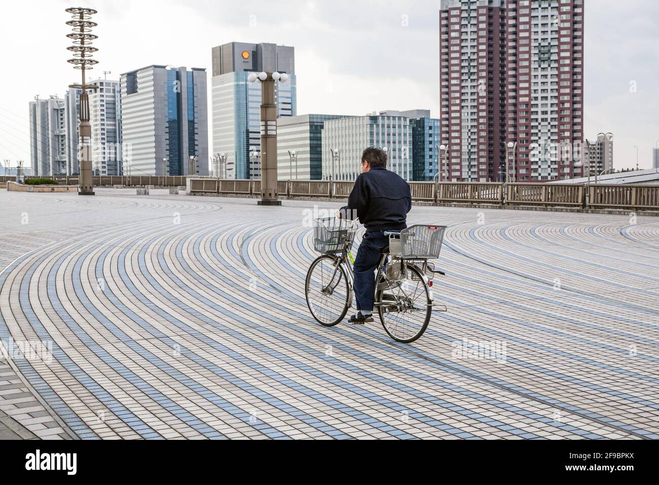 Japanese bicycle cycles over the patterned tiled walkway at Odaiba