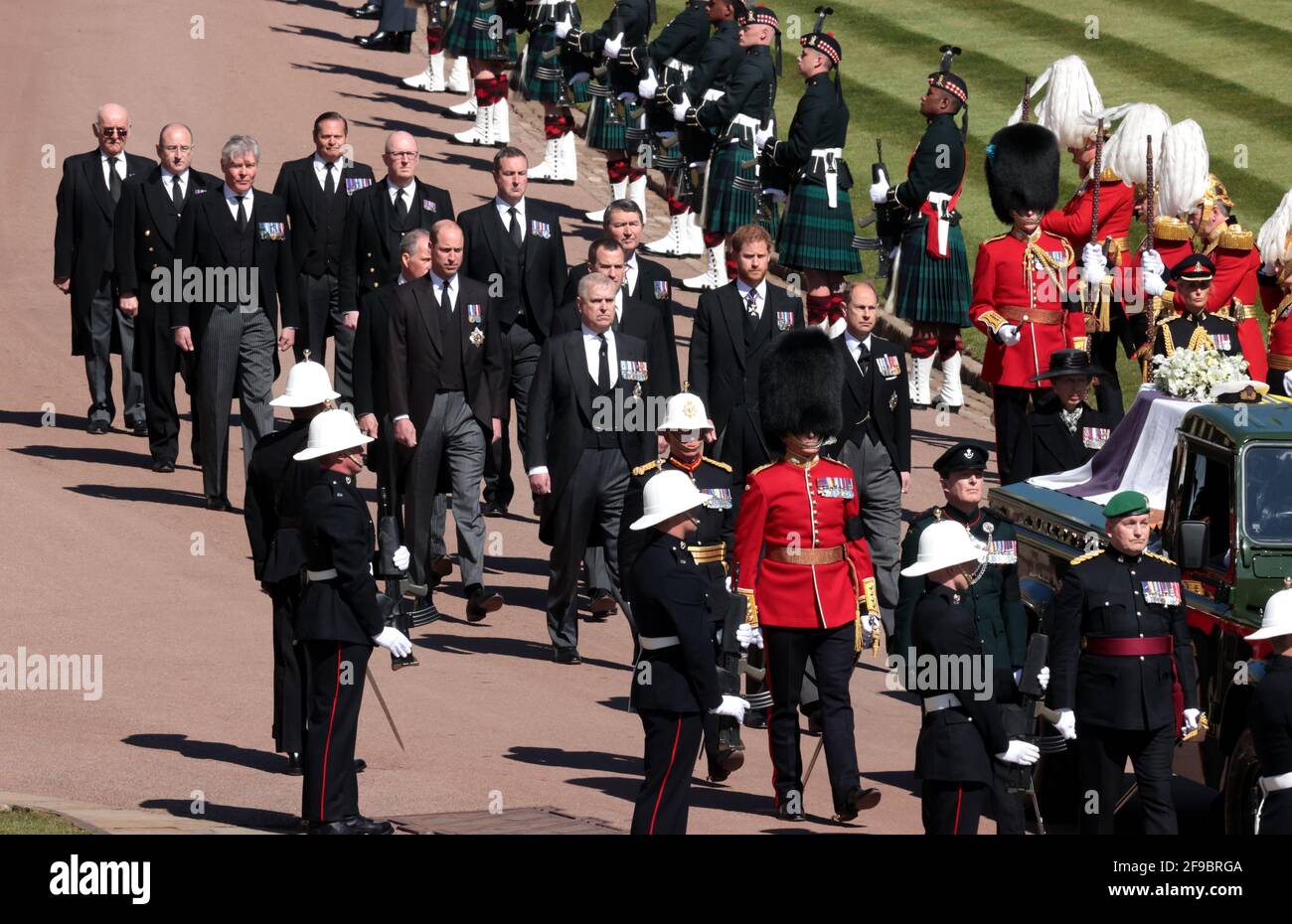 The Duke of York, the Duke of Cambridge, Peter Phillips, the Princess Royal, the Earl of Wessex, the Duke of Sussex, the Earl of Snowdon and Vice-Admiral Sir Timothy Laurence follow the Duke of Edinburgh's coffin, covered with his Personal Standard, on the purpose built Land Rover Defender outside St George's Chapel, Windsor Castle, Berkshire, ahead of the funeral of the Duke of Edinburgh. Picture date: Saturday April 17, 2021. Stock Photo