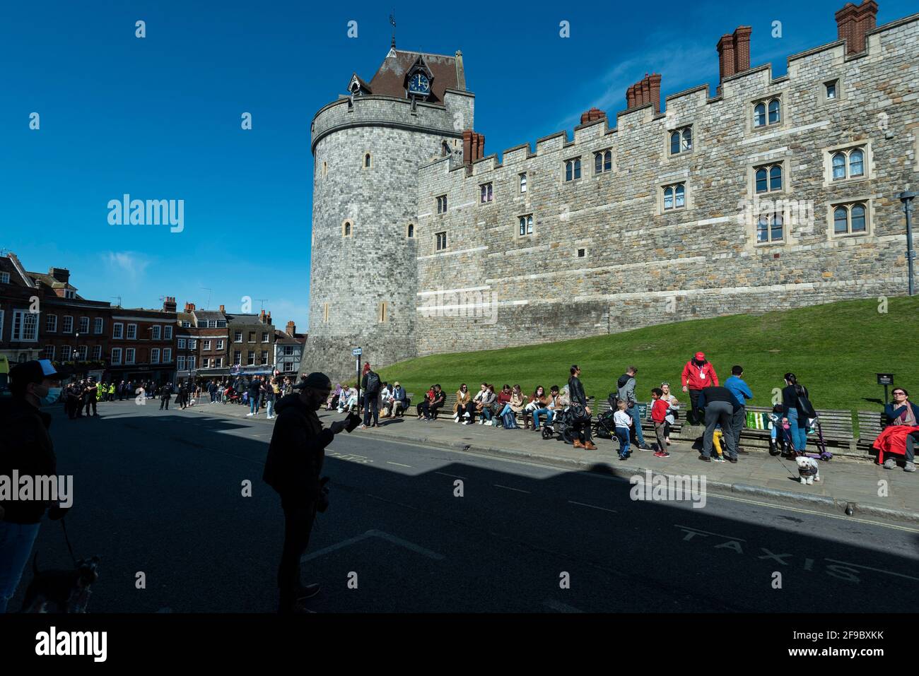 Windsor, UK. 17 April 2021. A clock shows 3pm on Windsor Castle, marking the start of a 2 minute silence, as crowds gather outside Windsor Castle on the day of the funeral of Prince Philip who died on 9 April, aged 99. Coronavirus pandemic restrictions have limited the number of mourners to 30 close family members at the 3pm funeral at Windsor Castle. Credit: Stephen Chung / Alamy Live News Stock Photo