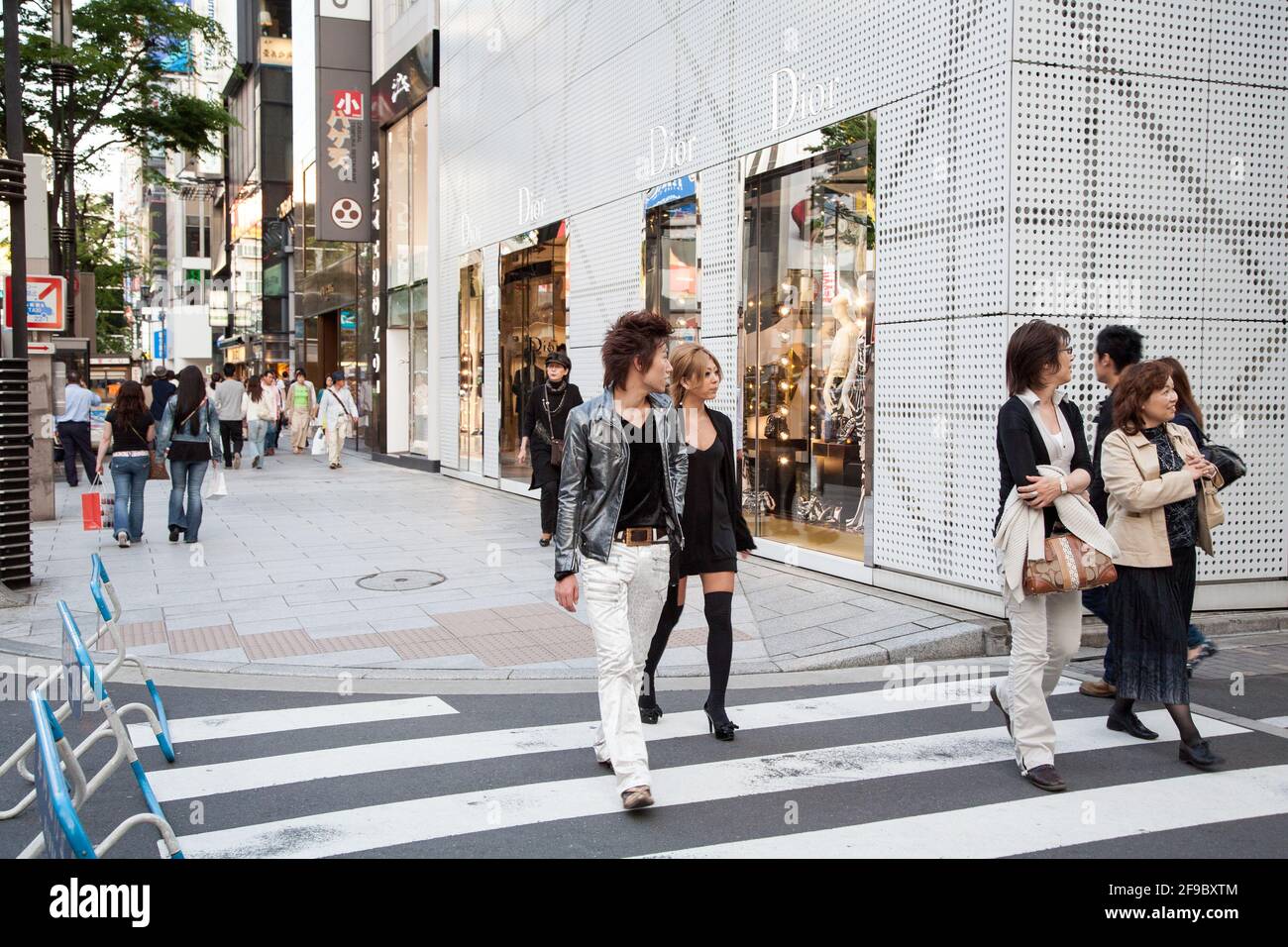 Trendy Japanese couple passing Dior store, Ginza, Tokyo, Japan Stock Photo