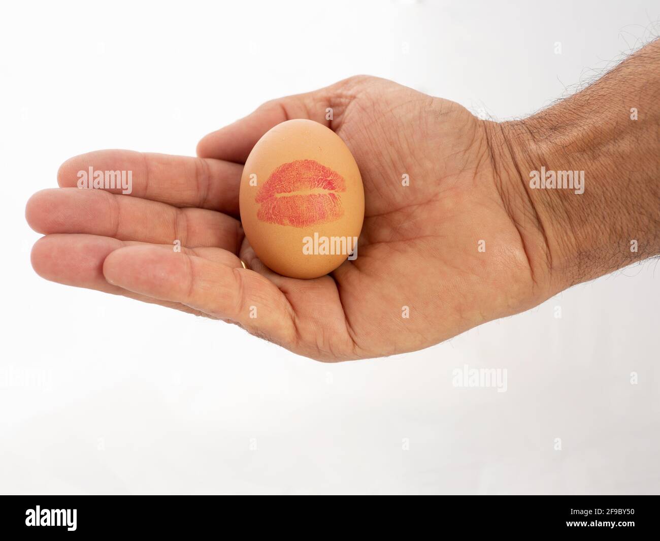 Hand holding an egg with a kiss Stock Photo
