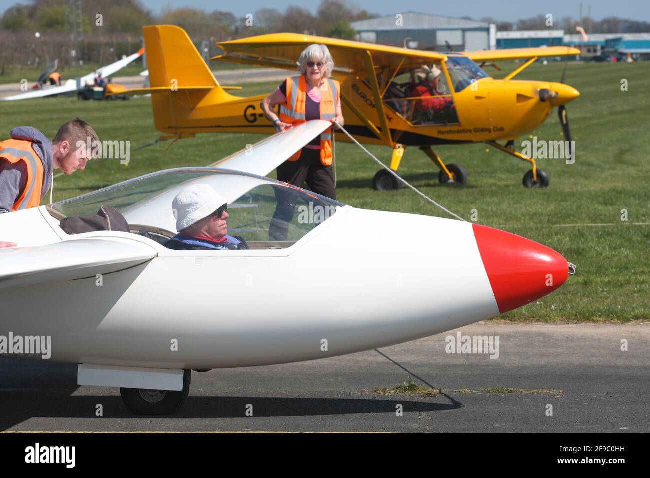 Shobdon, Herefordshire, UK - Saturday 17th April 2021 - UK Weather - Members of the Herefordshire Gliding Club enjoy warm Spring sunshine at Shobdon airfield as a Standard Libelle 201 glider is prepared for launch - local temperatures reached 13C with another fine sunny day forecast tomorrow. Photo Steven May / Alamy Live News Stock Photo