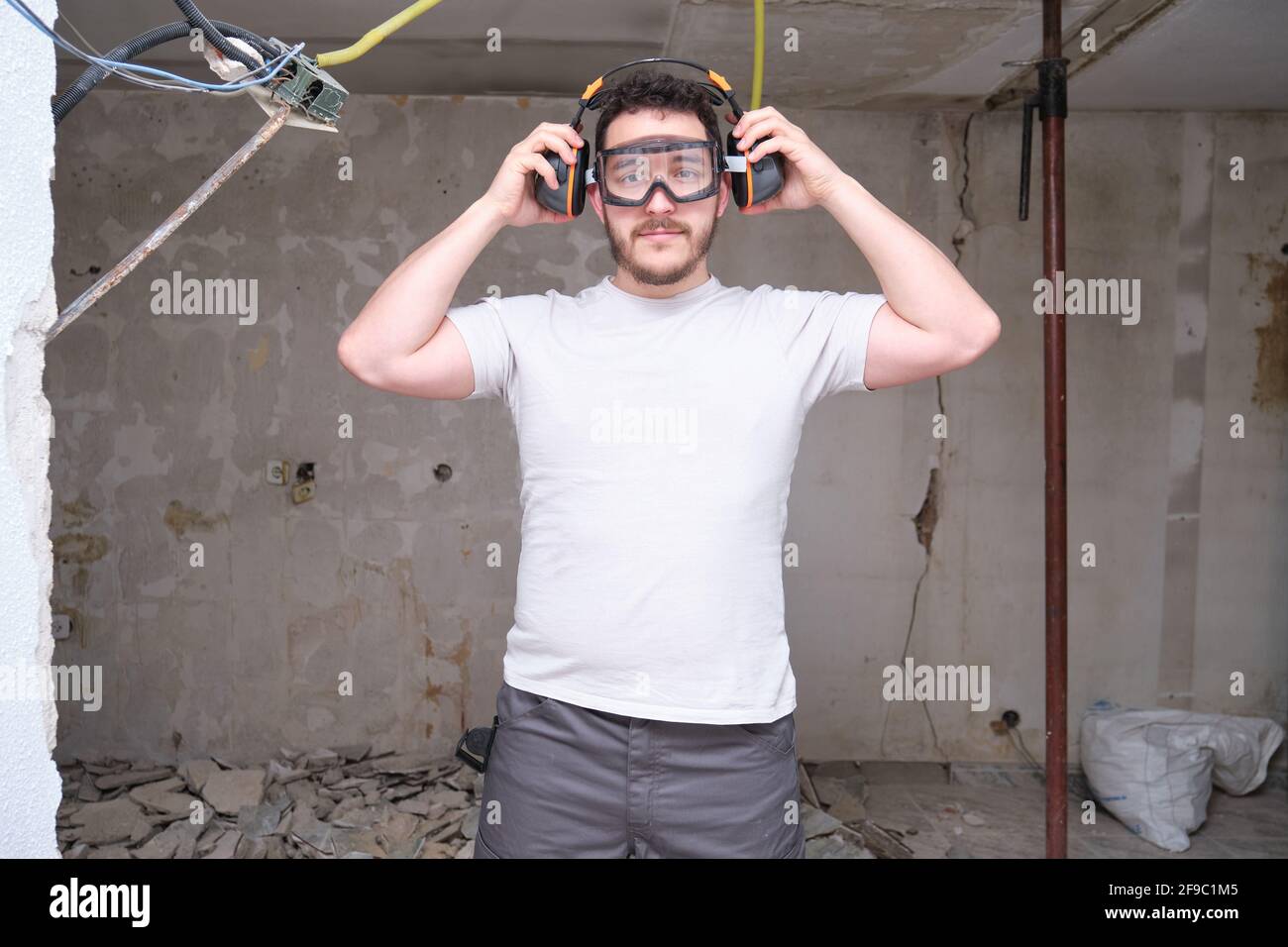 Young builder wearing hearing protection and safety glasses at a