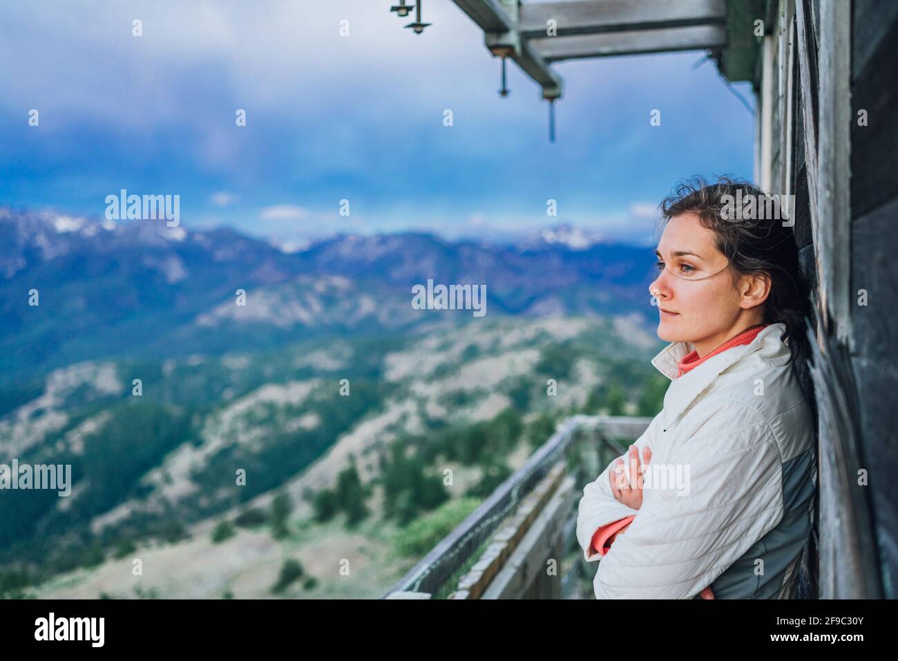 Young adventurer watching sunrise on top of fire lookout in Washington Stock Photo