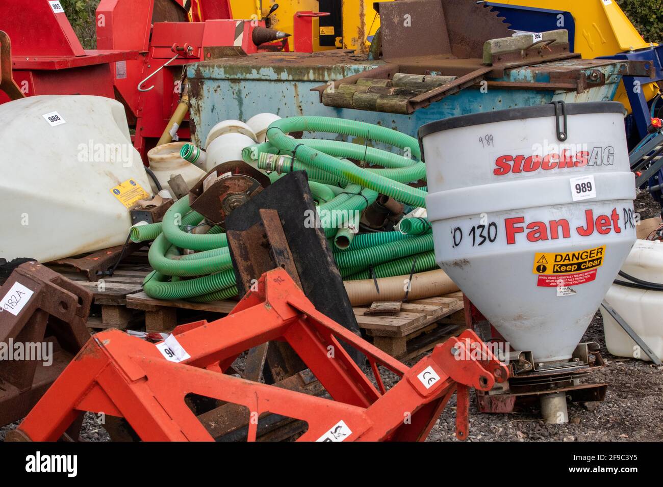 Lots including piping and metalwork piled up at an outdoor auction of