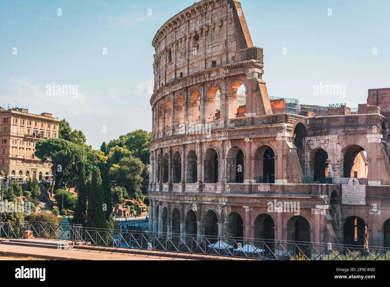 Coliseum, Colosseum, Rome, Italy. Ancient Roman Coliseum is famous landmark, top tourist attraction of Rome. Scenic view of Coliseum with trees and bl Stock Photo