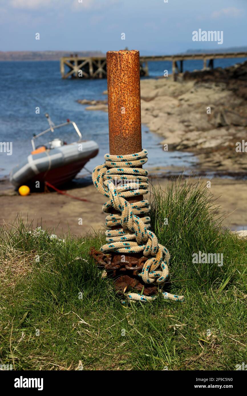 Rope and chain on a steel post at a small coastal harbour Stock Photo
