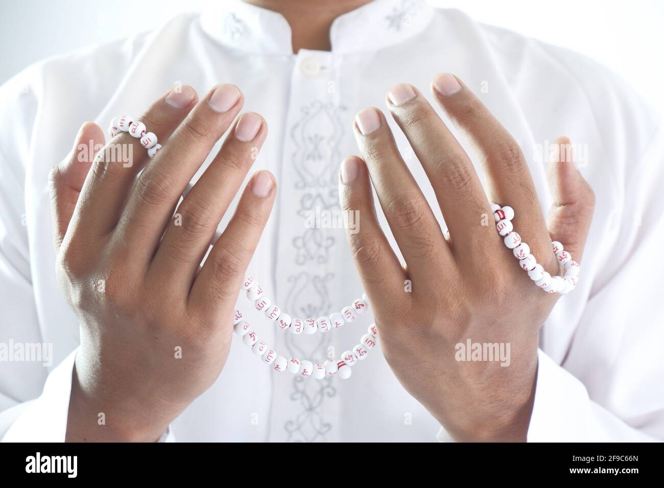 muslim man praying and holding prayer beads Stock Photo