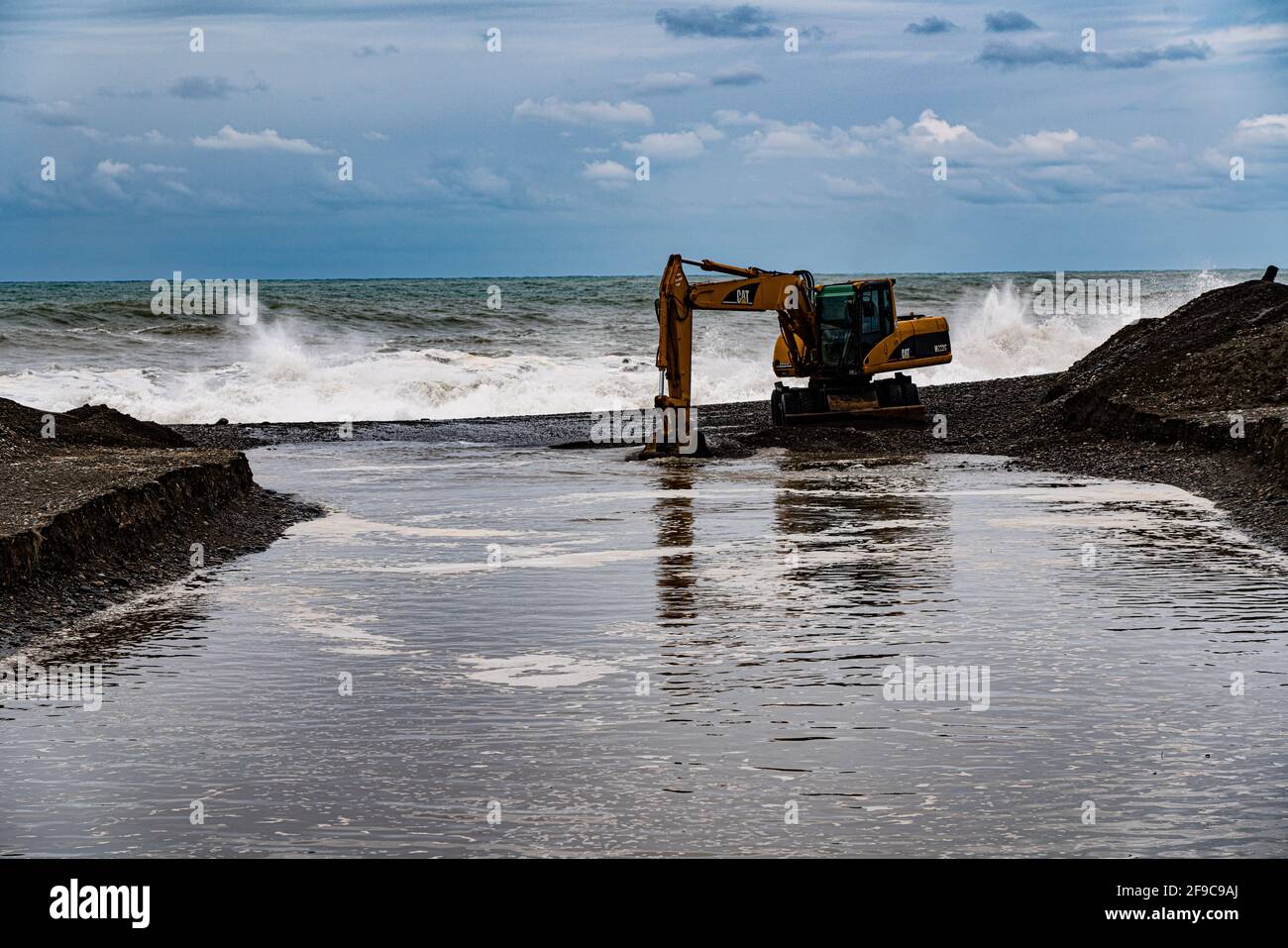 heavy yellow excavator working on the beach Stock Photo - Alamy