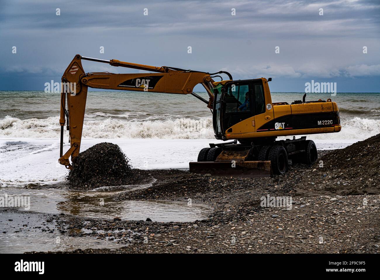 heavy yellow excavator working on the beach Stock Photo - Alamy