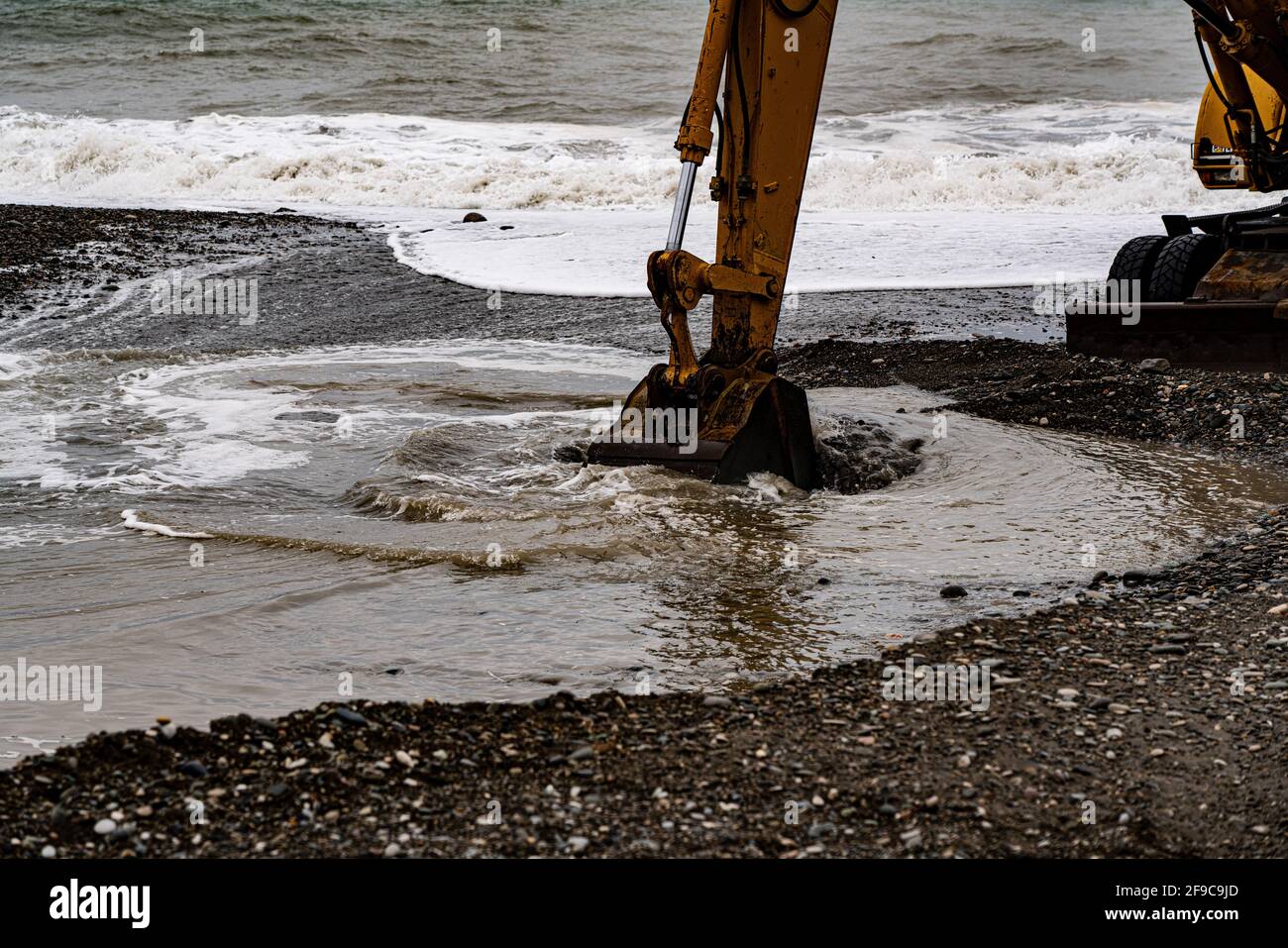 heavy yellow excavator working on the beach Stock Photo - Alamy