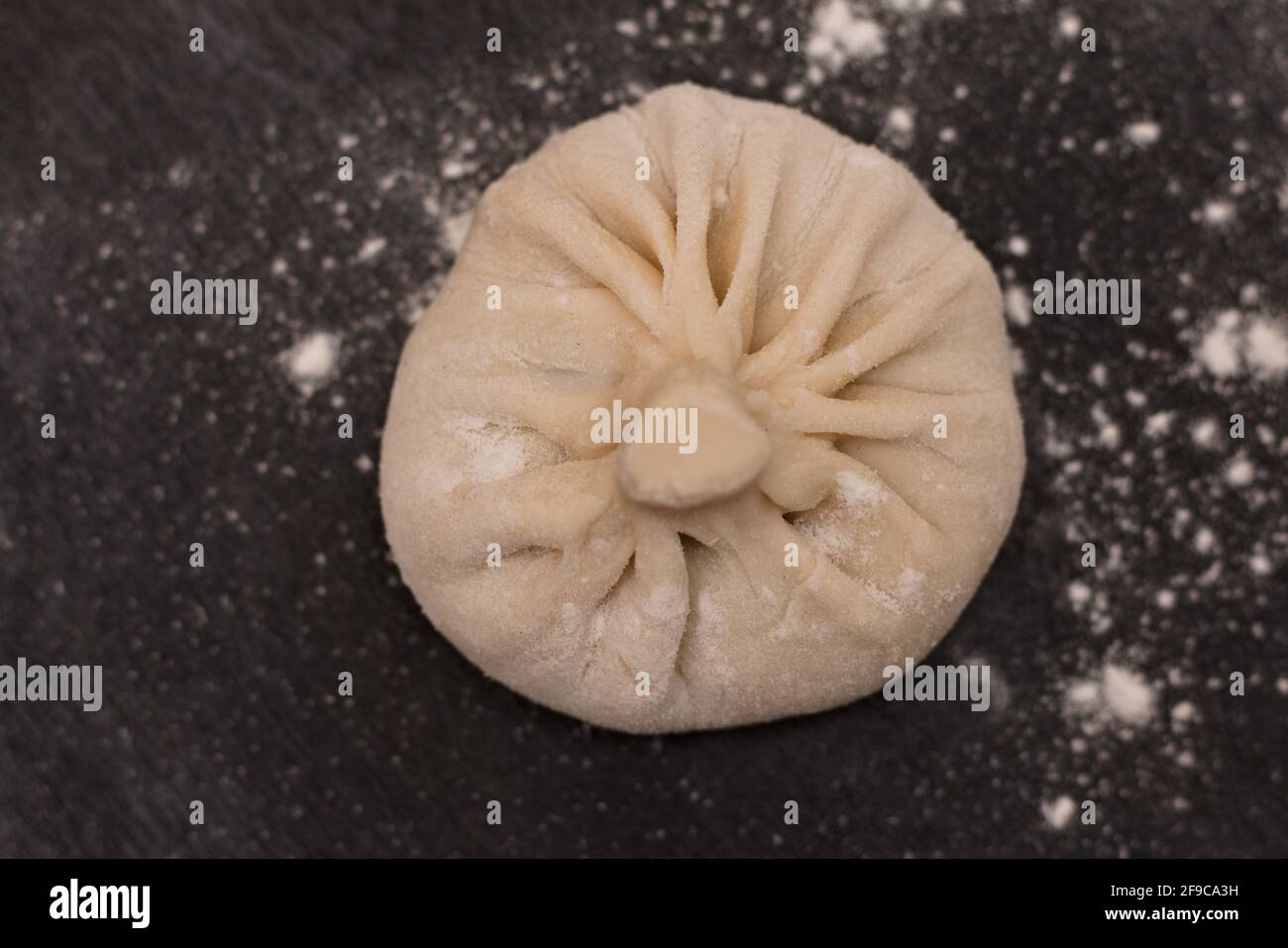 Raw Georgian khinkali on a black table. Top view Stock Photo