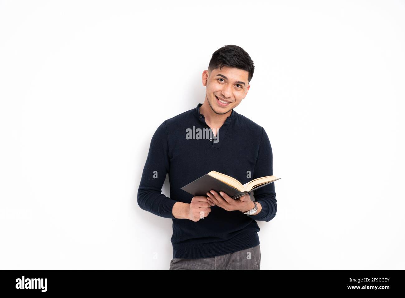 Caucasian man holding a book, smiling and looking at the camera isolated on a white background Stock Photo