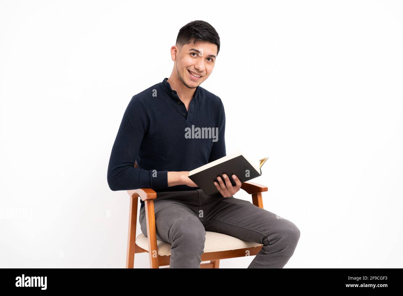 Caucasian man holding a book, smiling and looking at the camera isolated on a white background Stock Photo