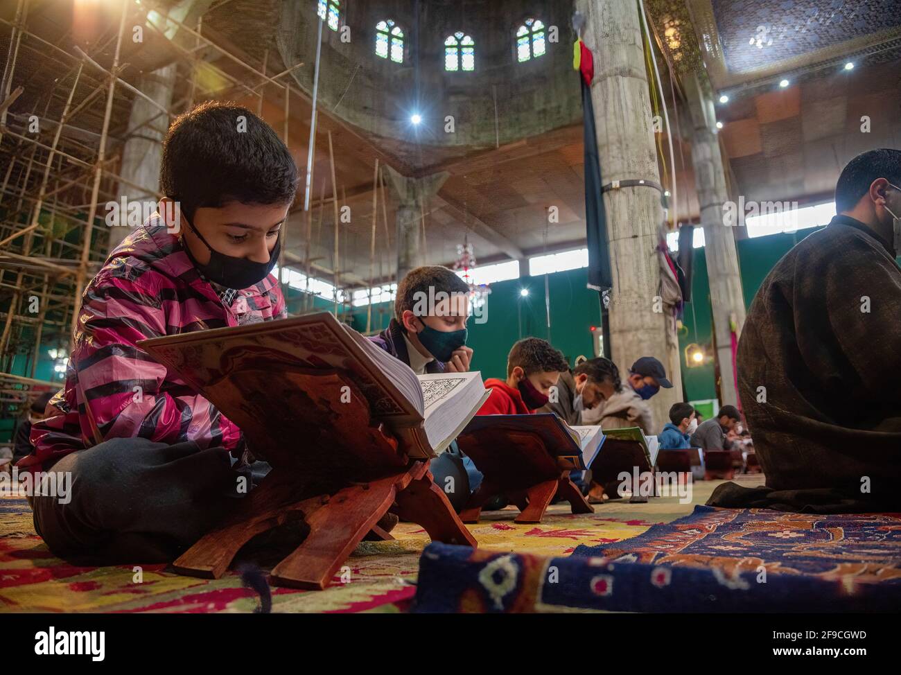 Kashmiri Muslim boys wearing face masks recite the Islamic Holy book ...