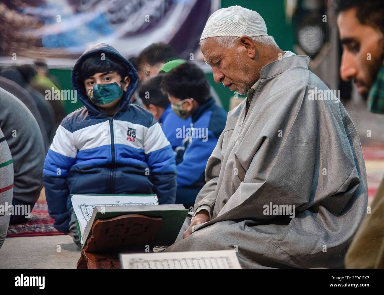 An old Muslim man recites the Islamic Holy book Qur'an during the ...