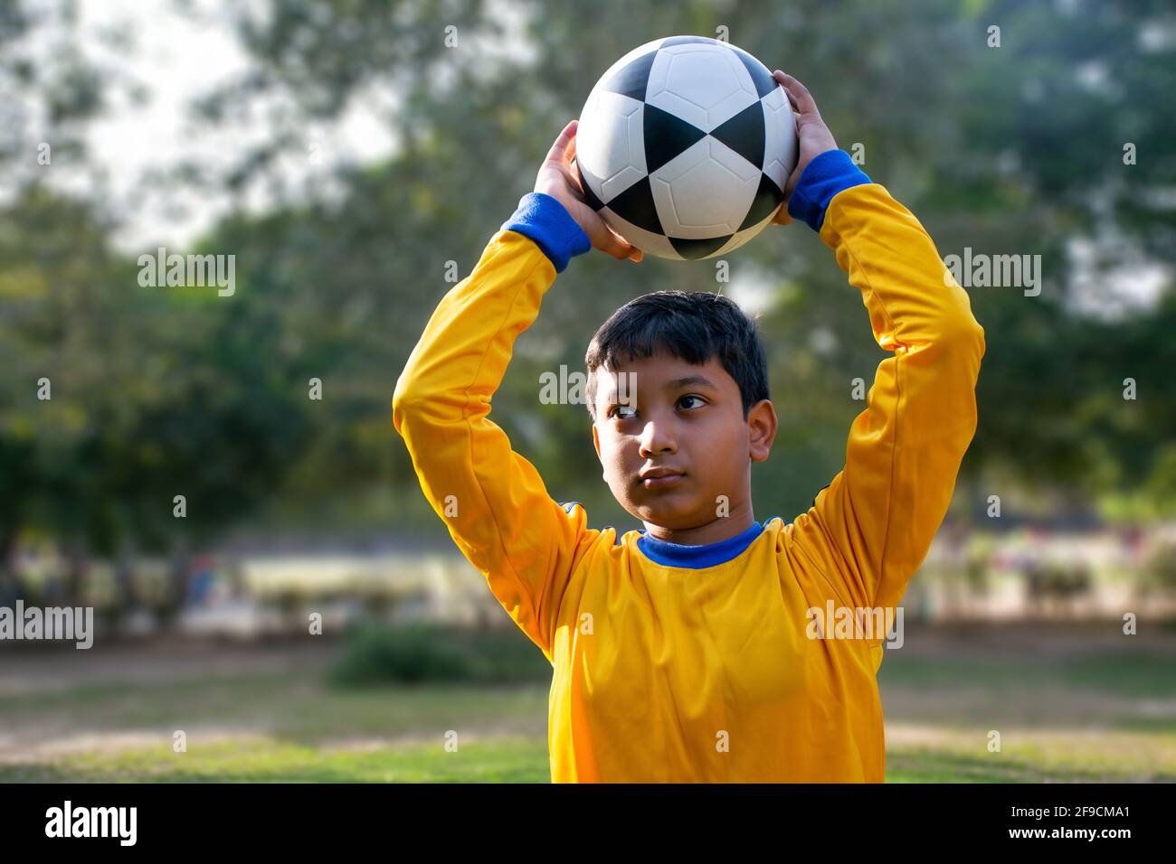 Portrait Of A Young Boy throwing football Stock Photo Alamy