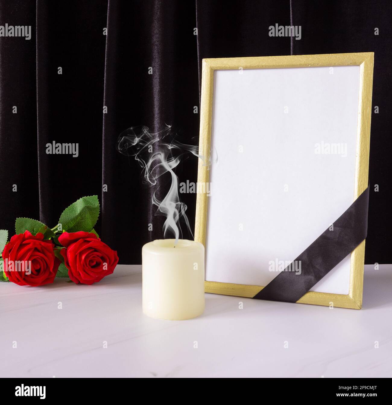 Photo frame with black mourning ribbon, roses and candle. The concept ...