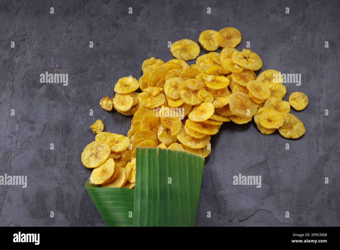 Dried banana chips or banana waffers spilled out from the banana leaf