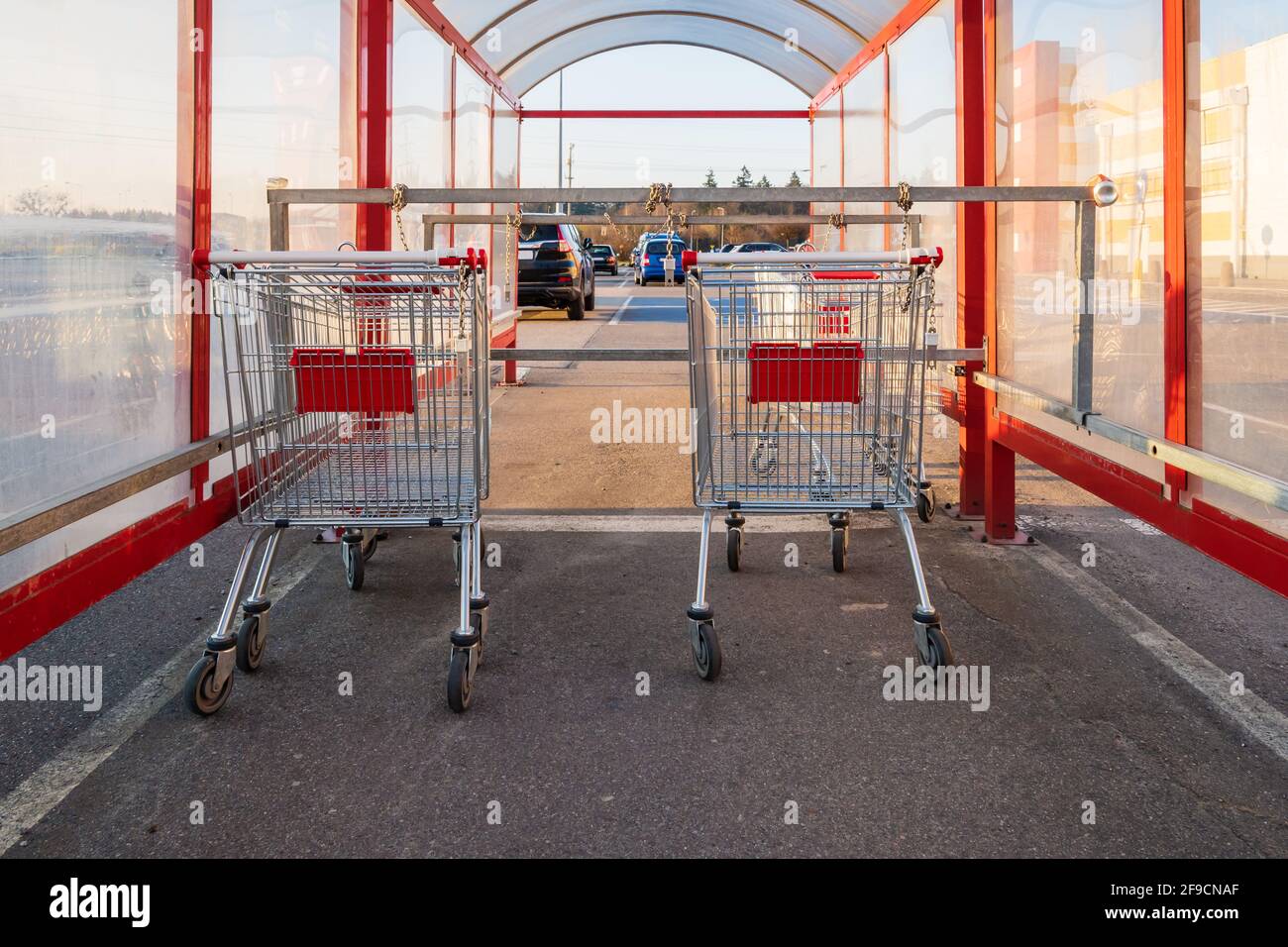 Shopping trolleys standing in row near hypermarket. Stock Photo