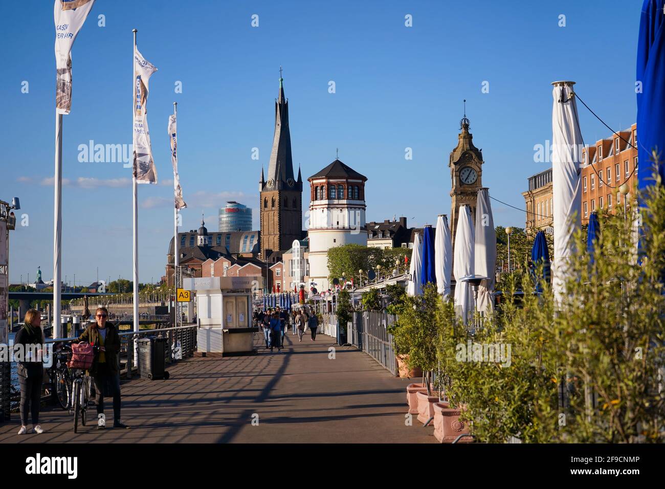 The popular Rhine promenade in Düsseldorf with Lambertus church and historic castle tower. Stock Photo