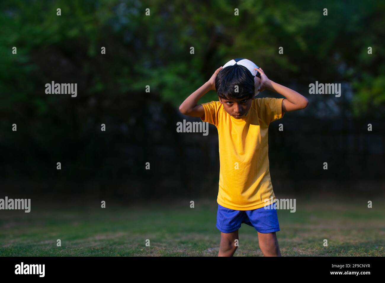 Portrait Of A Young Boy  throwing football Stock Photo