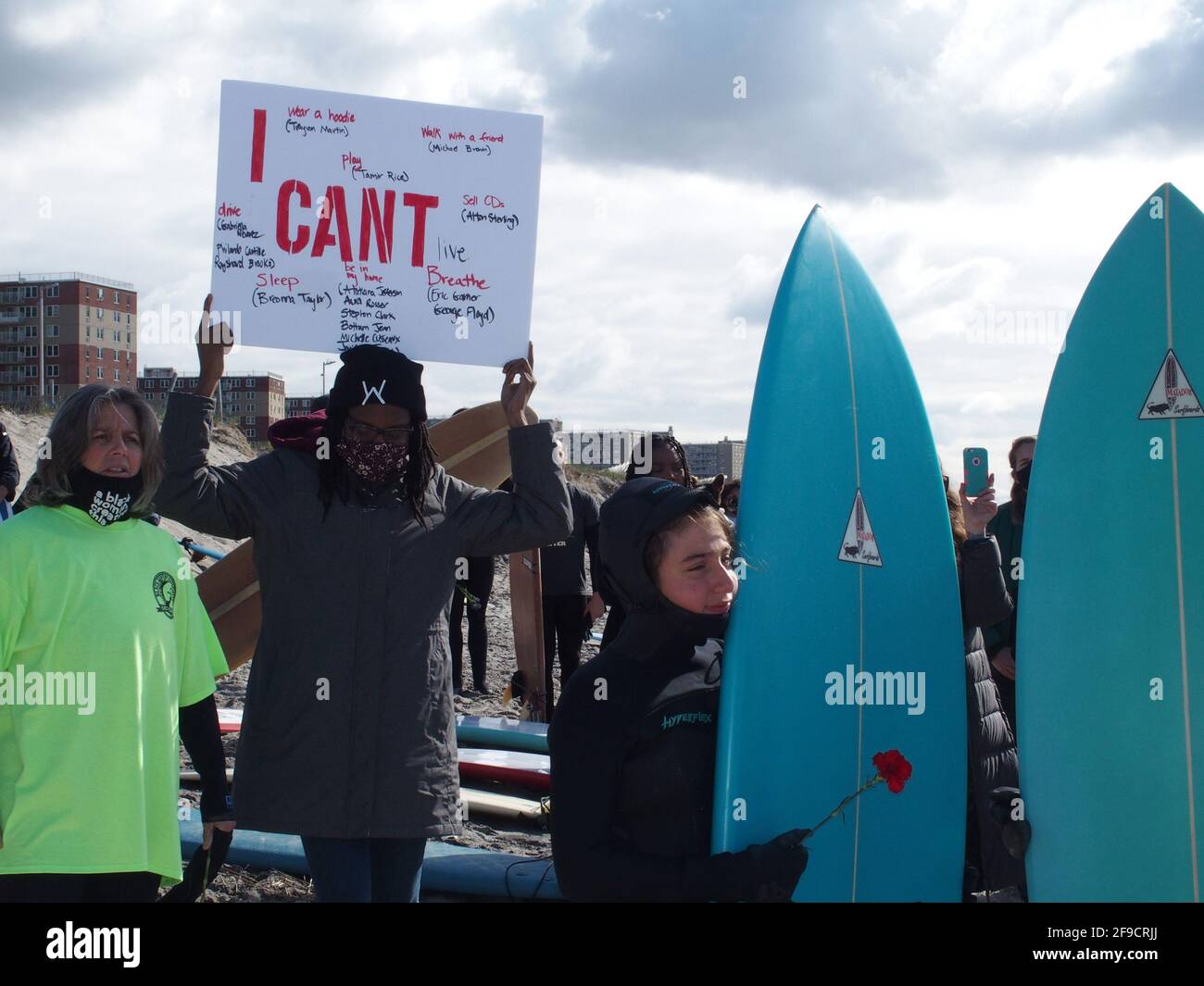 April 17, 2021, New York, New York, USA: NEW YORK -  Black Surfers Association have a paddle out to honor George Floyd and Daunte Wright in Far Rockaway Queens at Beach 91st. Street. Surfers take to the water hold a prayer circle and place flowers in the water while family members and friends hold signs on the beach. (Credit Image: © Bruce Cotler/ZUMA Wire) Stock Photo