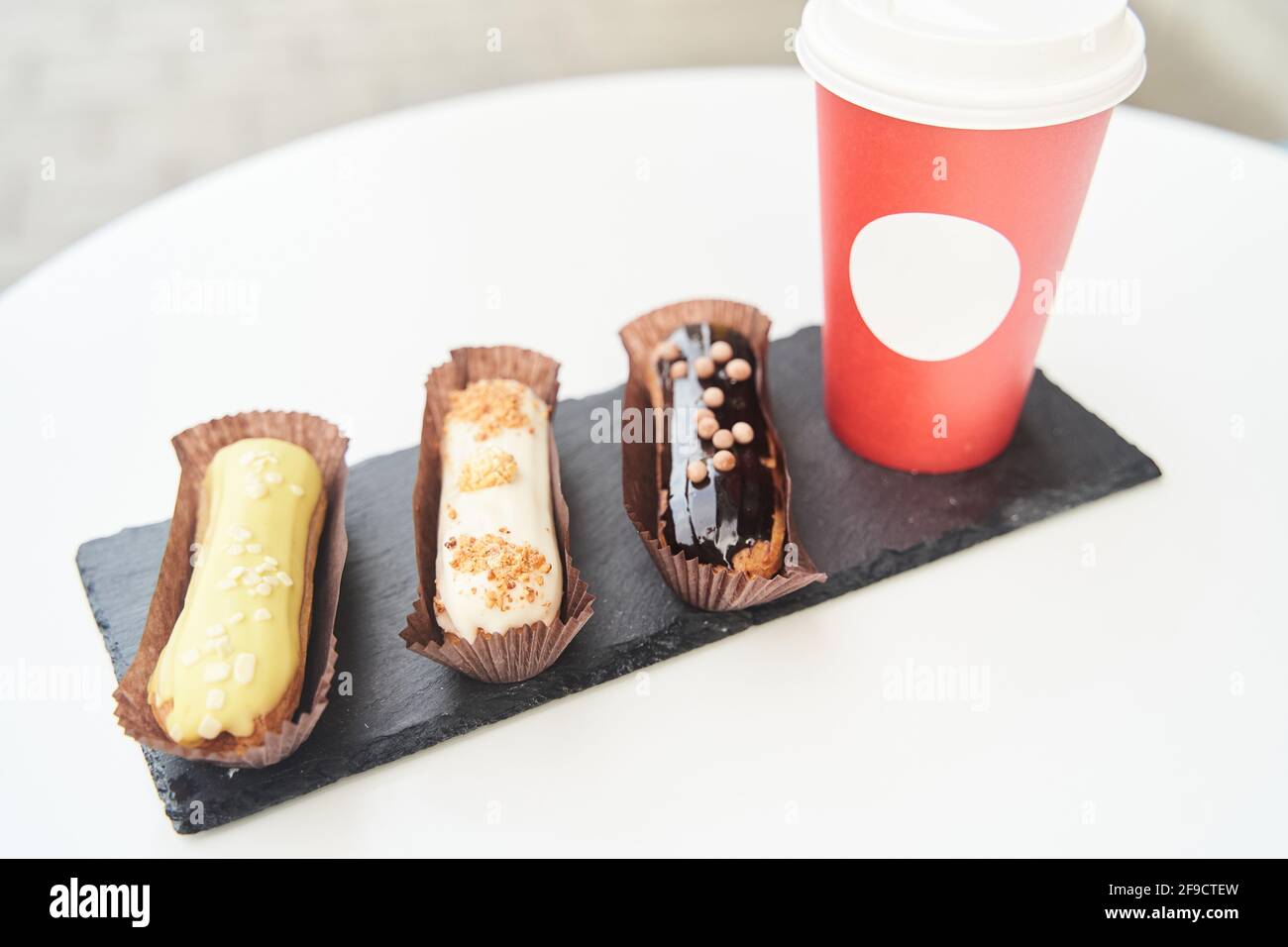 Three eclairs on a black tray top view Stock Photo