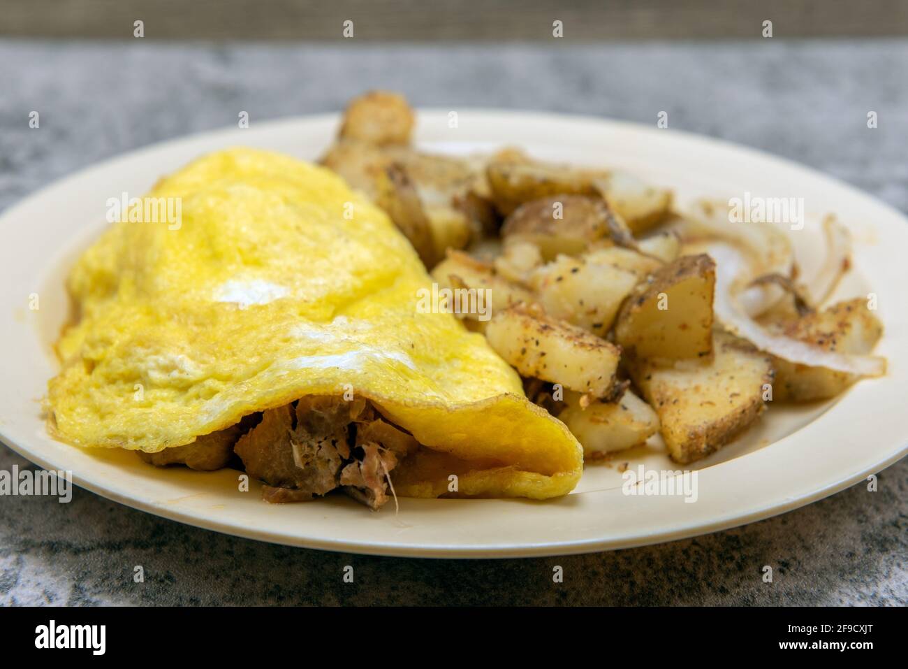 Chili verde pork meat omelette served with seasons roasted potatoes as a traditional Mexican food breakfast. Stock Photo