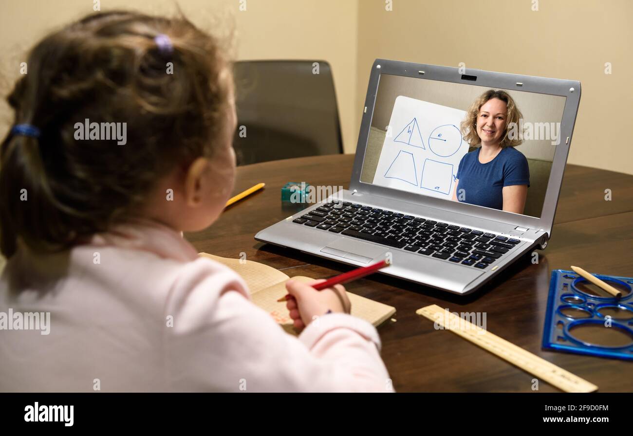 Elearning online study at home, kid learning with teacher by laptop. Tutor teaches preschool child, person look at teacher on computer screen. Concept Stock Photo