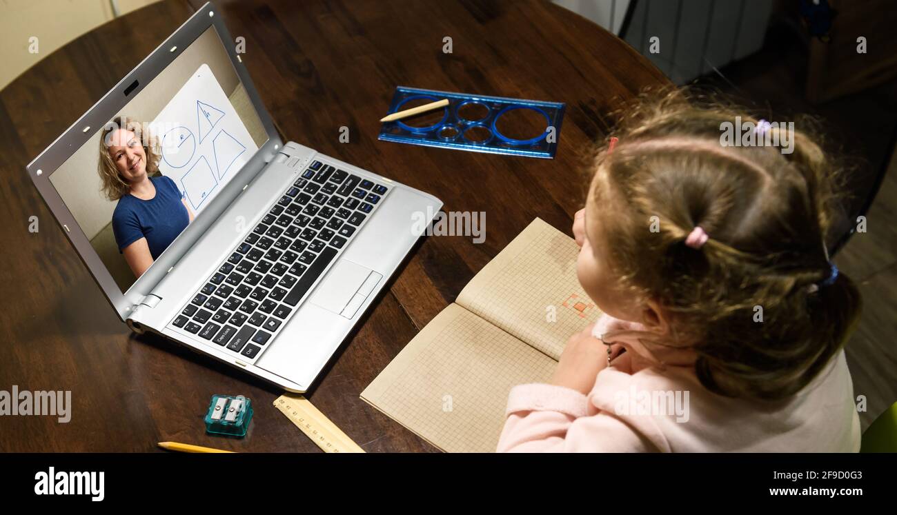 Elearning online study at home, kid learning with teacher by laptop. Tutor teaches preschool child, person look at teacher on computer screen. Concept Stock Photo