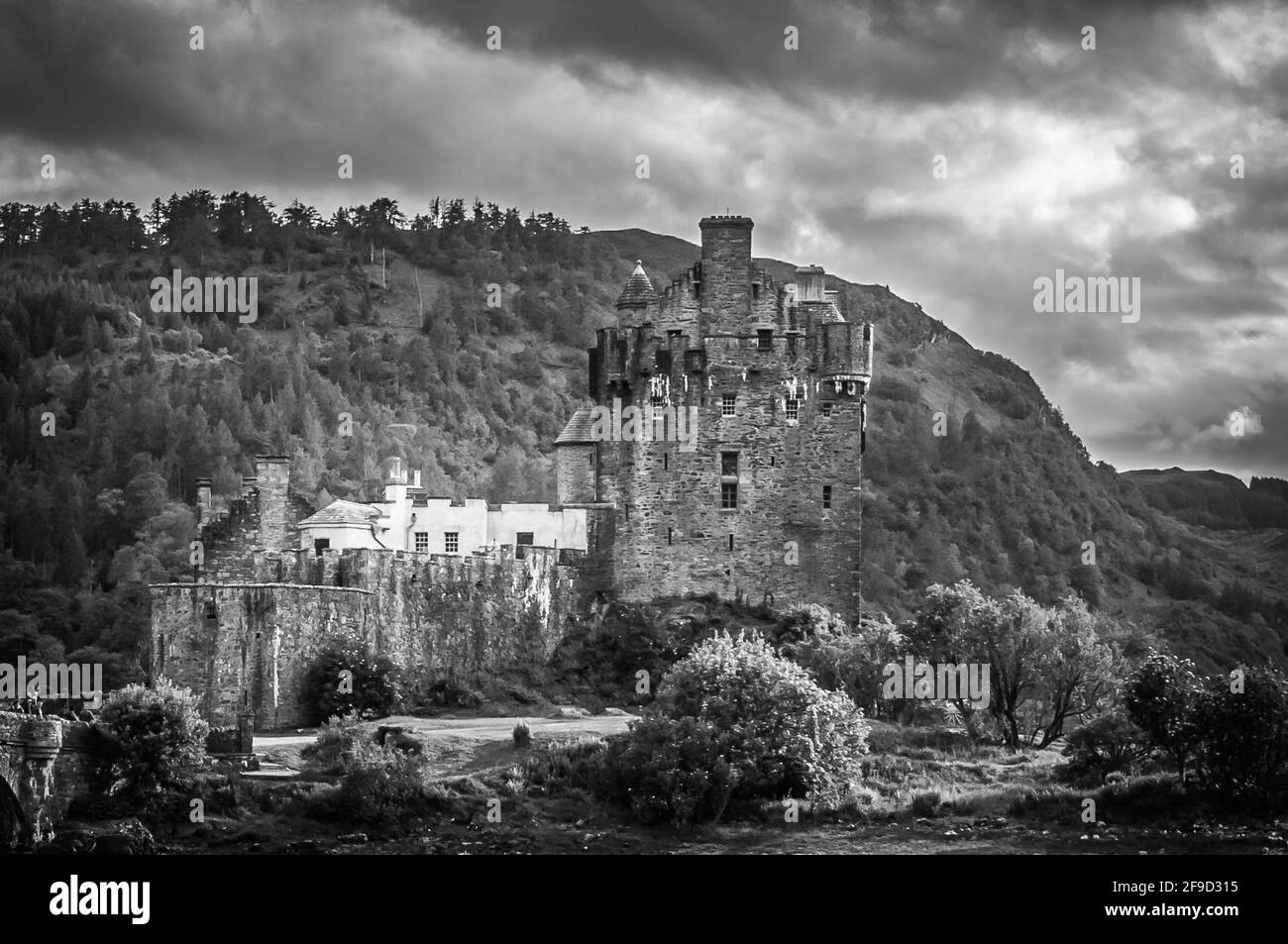 Black and white effect of Eilean Donan Castle with hill in the background, Scotland. Concept: fantastic and mythological places, travel to famous plac Stock Photo