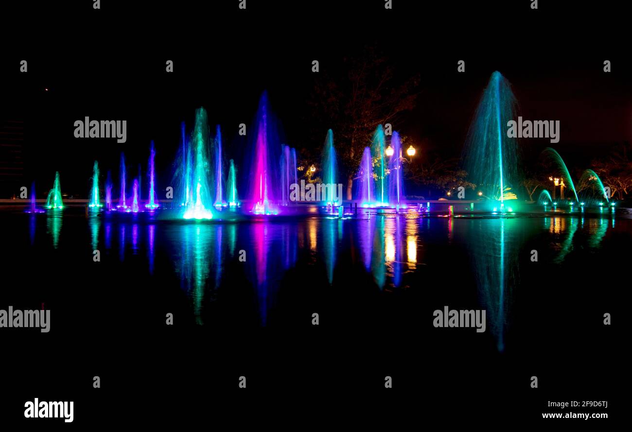Bright colourful fountain against a dark sky Stock Photo