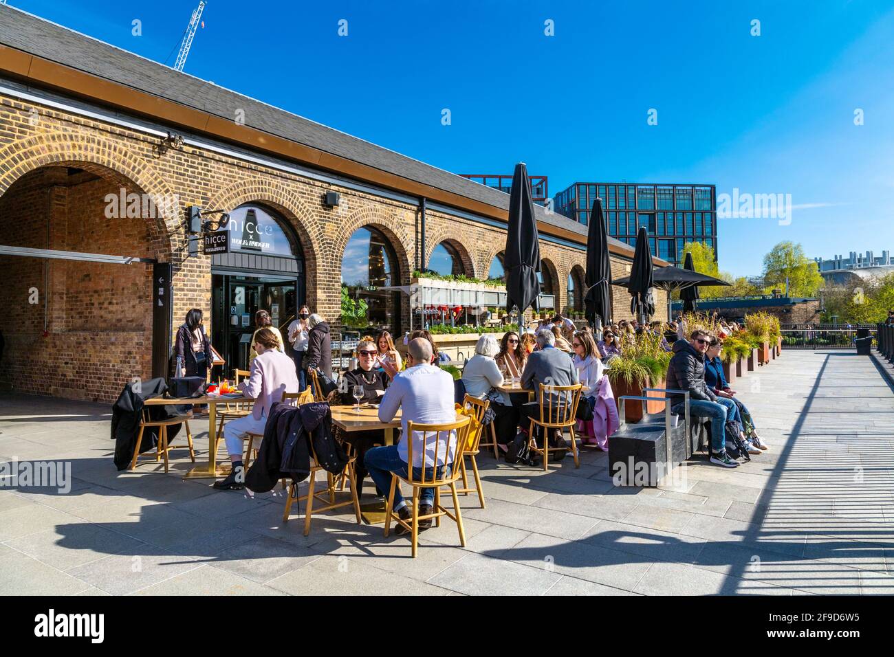 17th April 2021 - London, UK, People dining al fresco at a restaurant in Coal Drops Yard, Kings Cross on a sunny weekend after easing of coronavirus pandemic lockdown Stock Photo