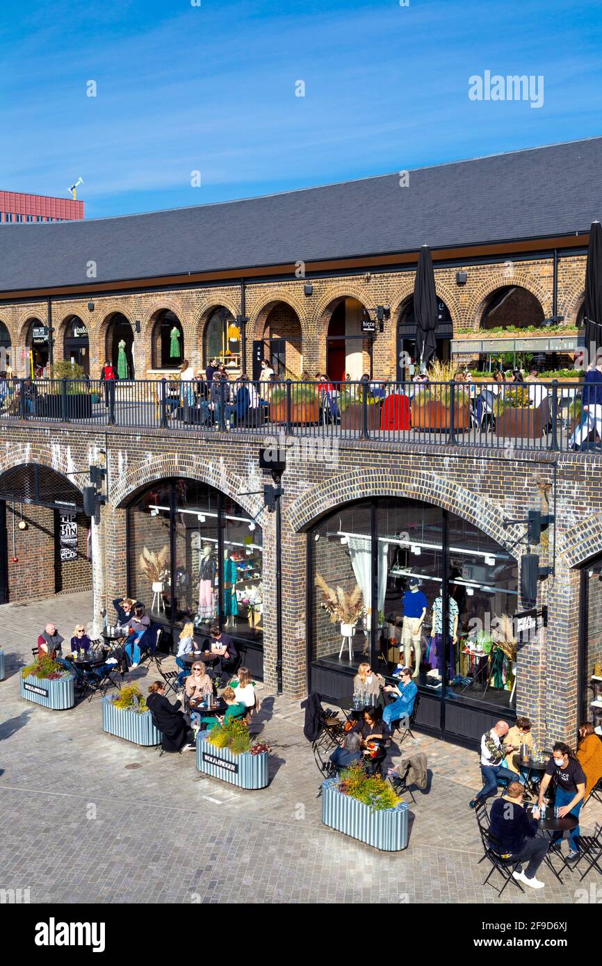 17th April 2021 - London, UK, People dining al fresco at a restaurant in Coal Drops Yard, Kings Cross on a sunny weekend after easing of coronavirus pandemic lockdown Stock Photo