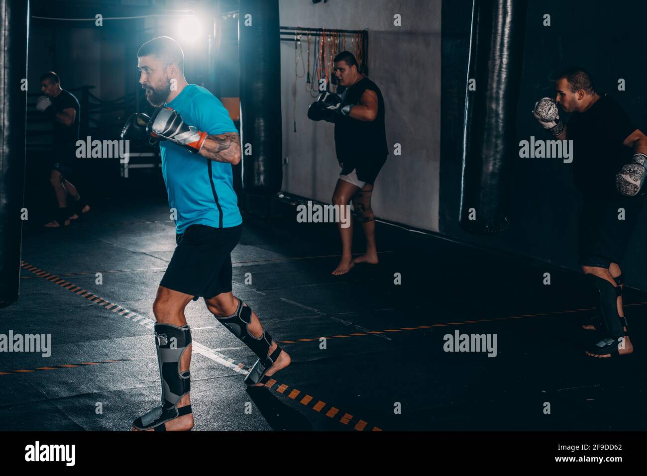 Boxer man during boxing hitting heavy bag at training fitness gym Stock