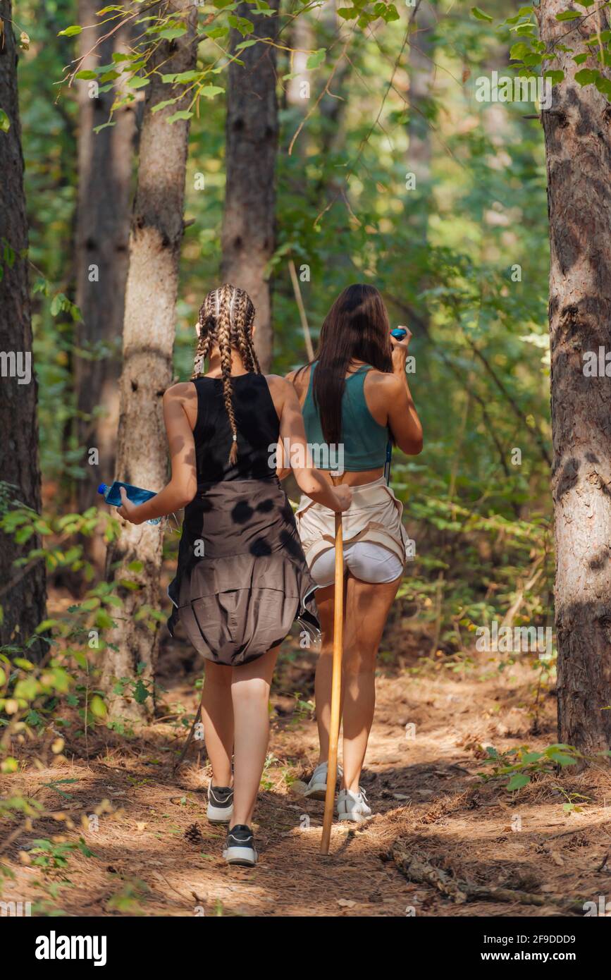 Two female caucasian friends hiking in the woods on a mountain on a ...