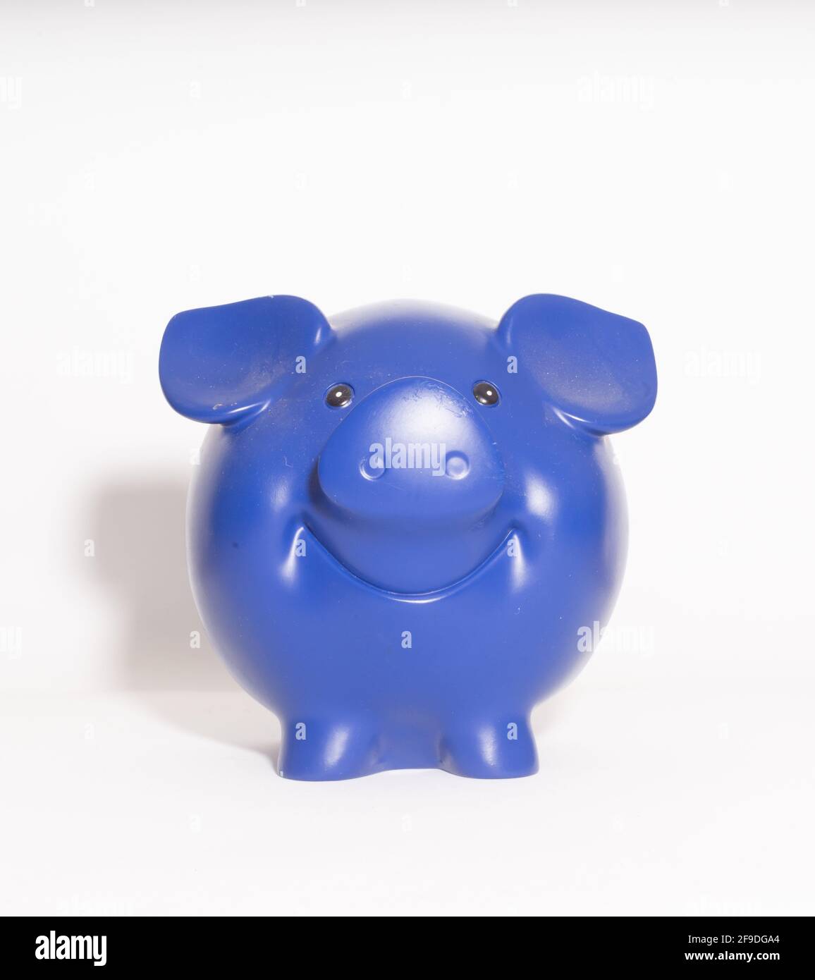 A closeup view of a blue ceramic piggy money bank isolated on a white ...