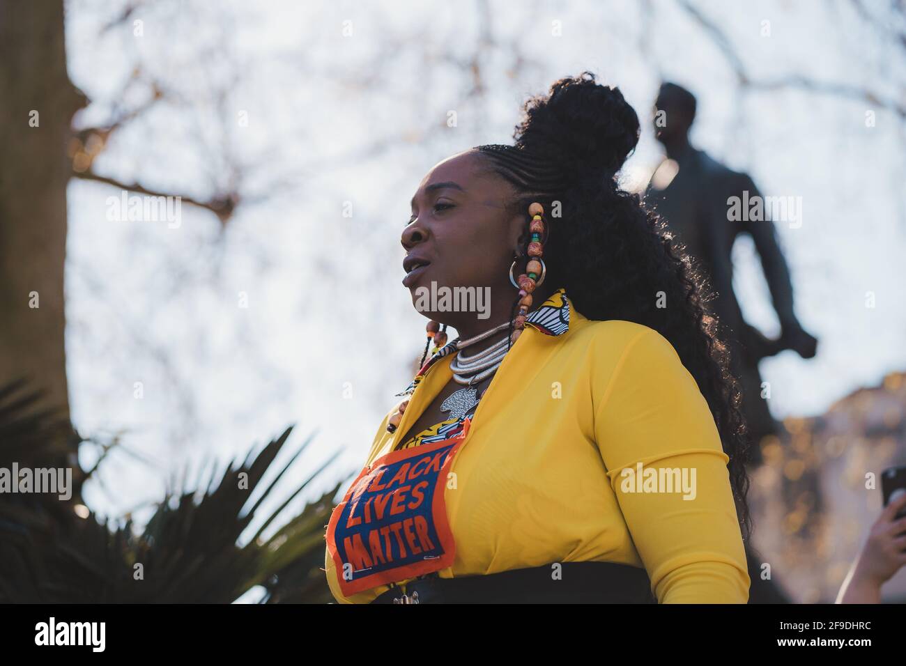 Westminster, London | UK - 2021.04.17: Lady in yellow costume with Black Lives Matter sign giving a speach at the Kill the Bill protest Stock Photo