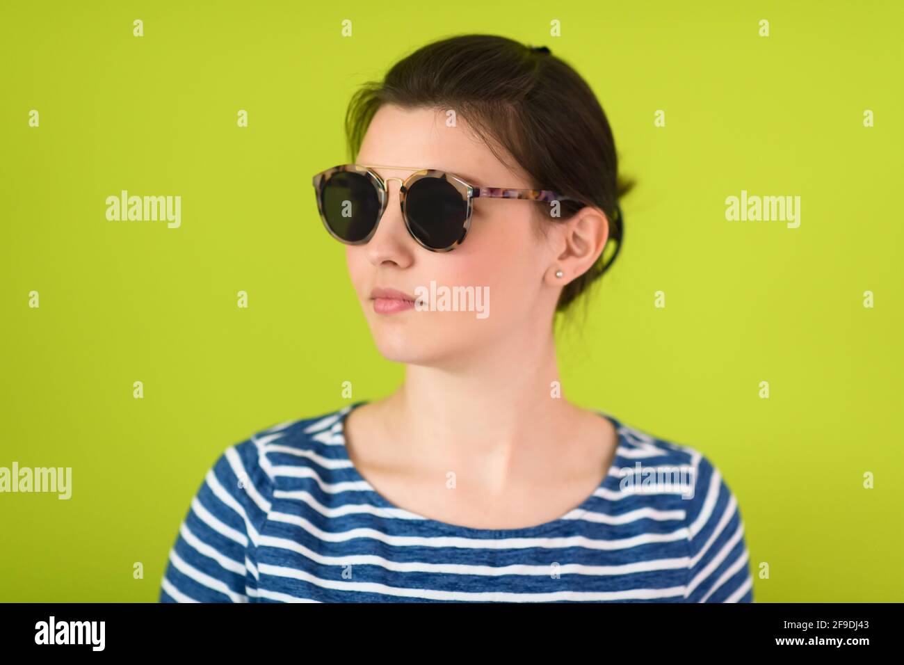 woman in sunglasses posing in front of a green background Stock Photo ...