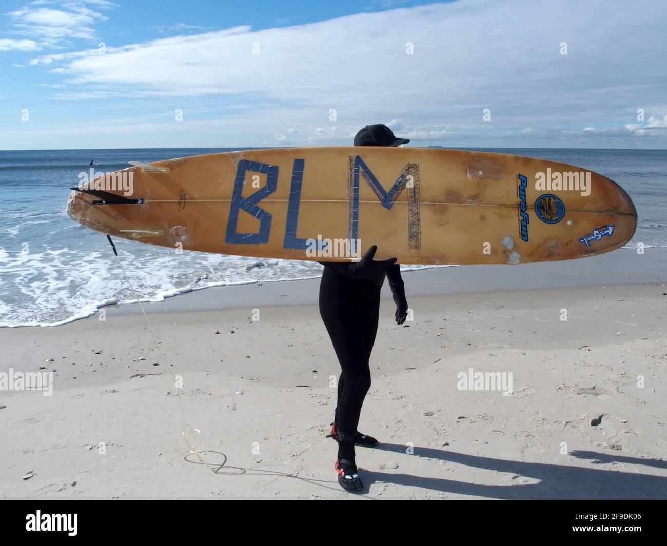 New York, New York, USA. 17th Apr, 2021. NEW YORK - Black Surfers Association have a paddle out to honor George Floyd and Daunte Wright in Far Rockaway Queens at Beach 91st. Street. Surfers take to the water hold a prayer circle and place flowers in the water while family members and friends hold signs on the beach. Credit: Bruce Cotler/ZUMA Wire/Alamy Live News Stock Photo