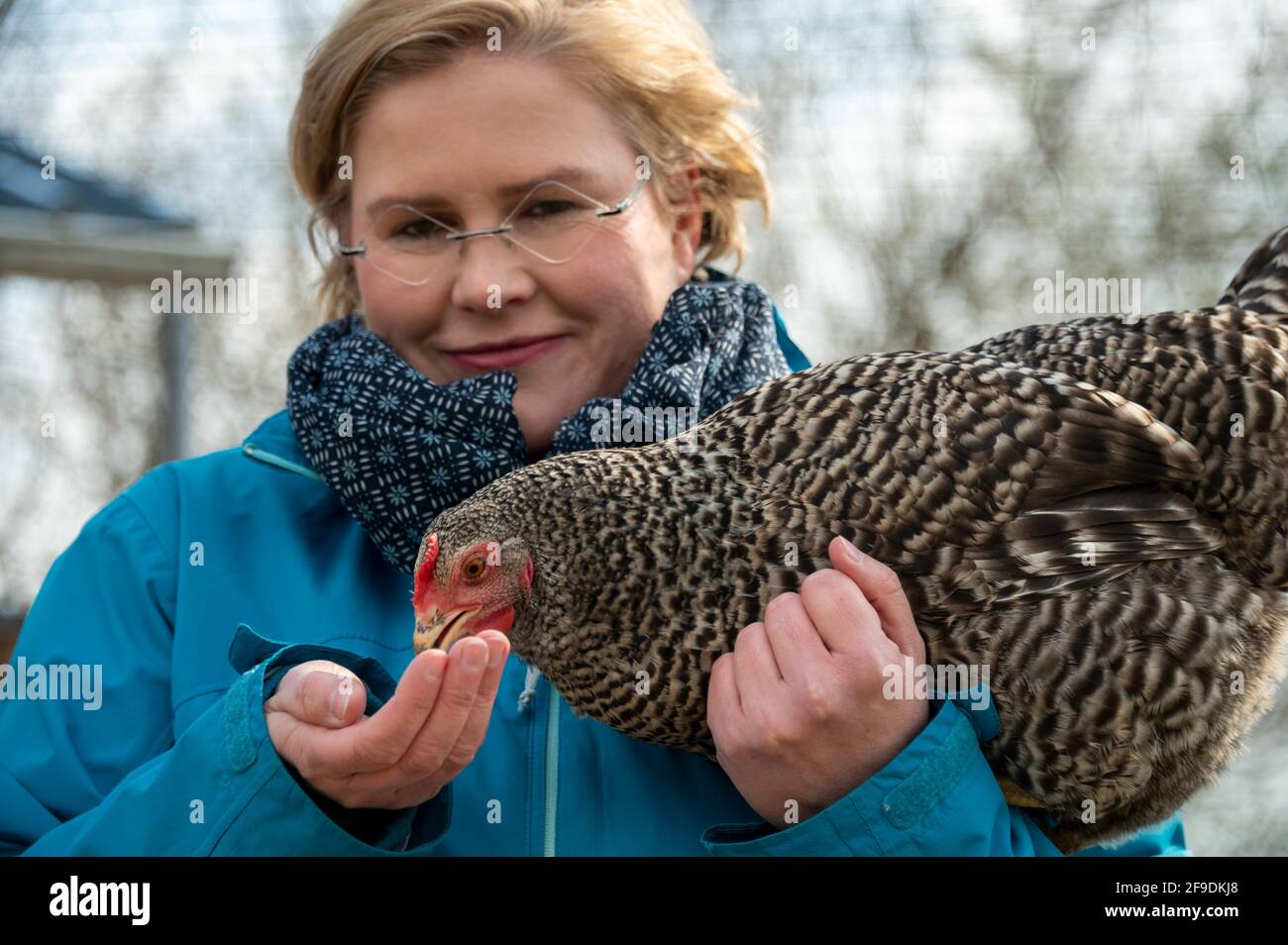 Bleckhausen, Germany. 14th Apr, 2021. Karin Jaskowsky feeds one of 20 village chickens in the