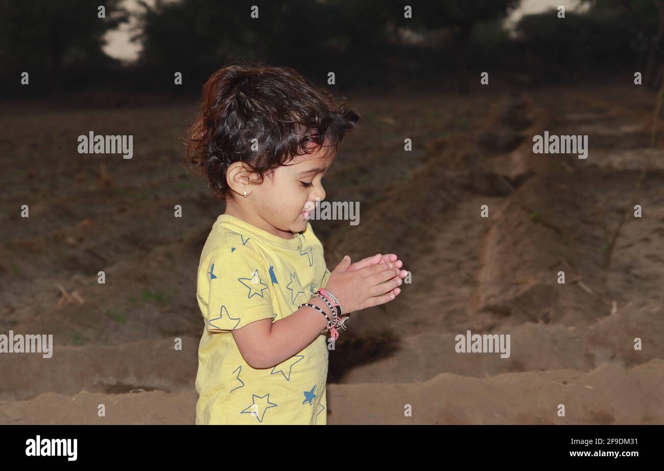 Close-Up side view shot of An Indian little boy clapping in the field Stock Photo