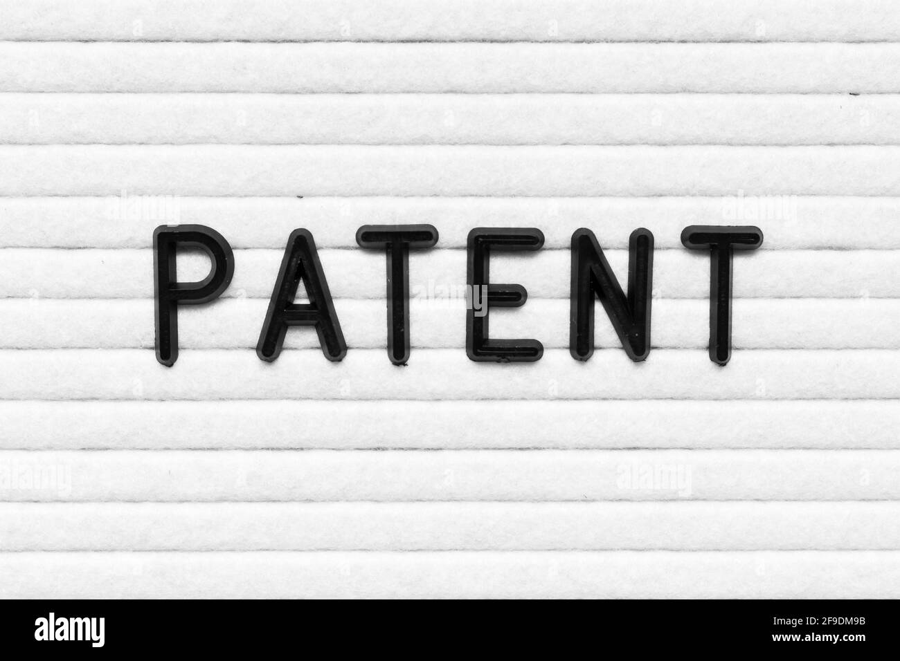 Black alphabet letter in word patent on white felt board background Stock Photo